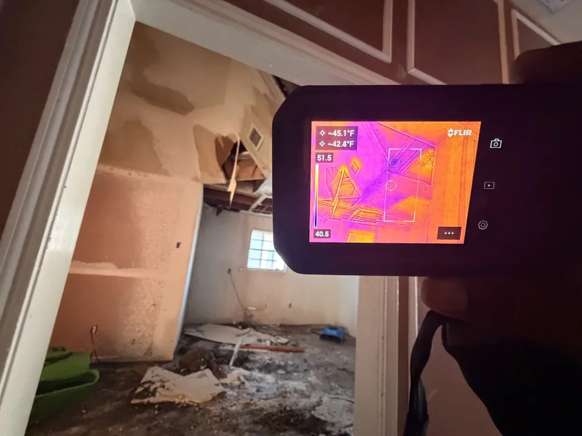 Thermal imaging camera checking for hidden moisture after a water-damaged ceiling came down