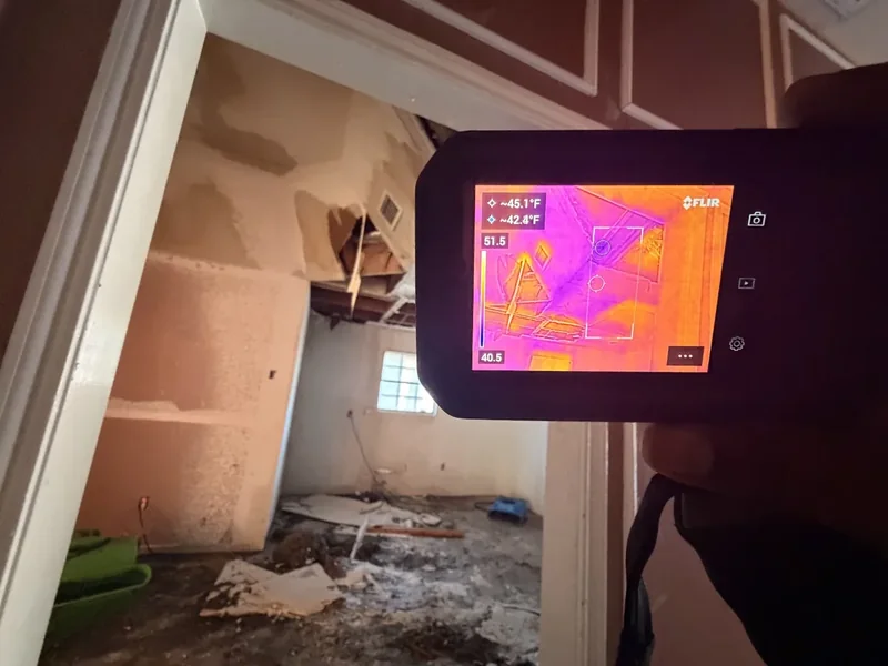 Thermal imaging camera checking for hidden moisture after a water-damaged ceiling came down