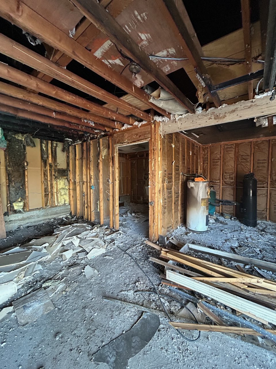 Charred structural framing and soot residue after a house fire