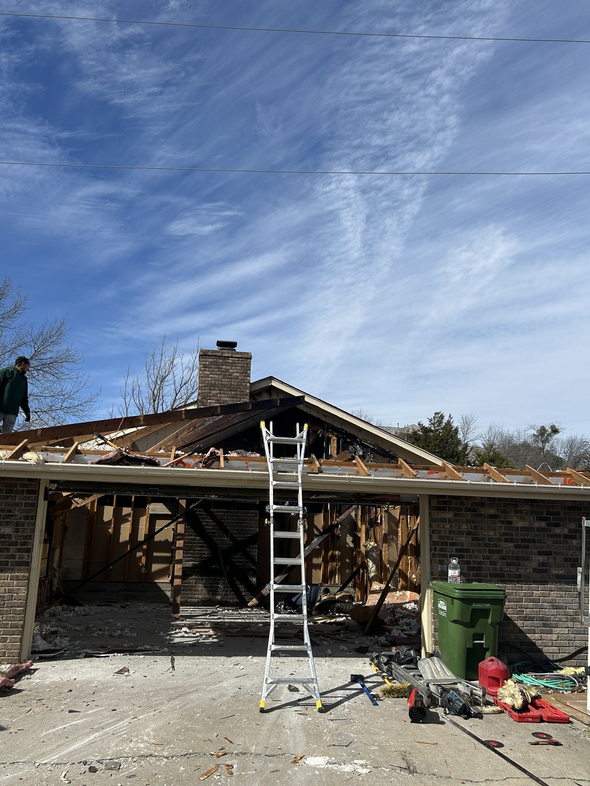 Fire-damaged garage exterior during cleanup, prior to odor treatment